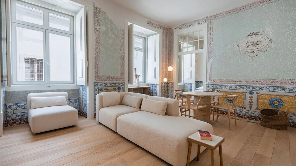 Una luminosa sala de estar y comedor con asientos claros y una mesa de madera.
