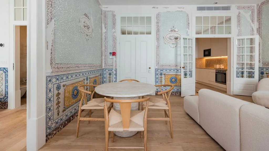 Un comedor con una mesa redonda está junto a una cocina abierta y una sala de estar.