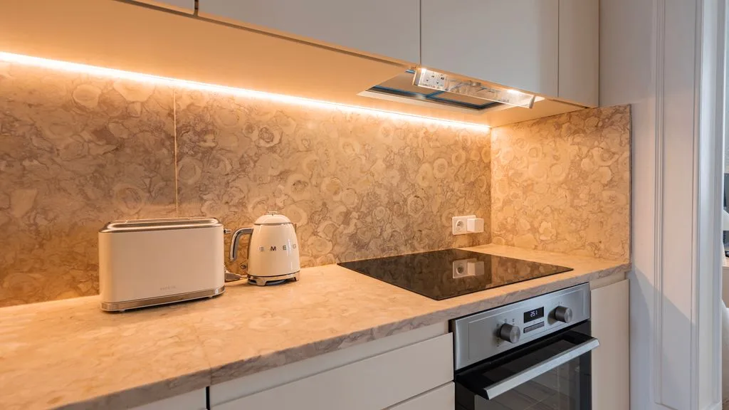 Una cocina moderna con encimera, pequeños electrodomésticos y una placa de cocción.