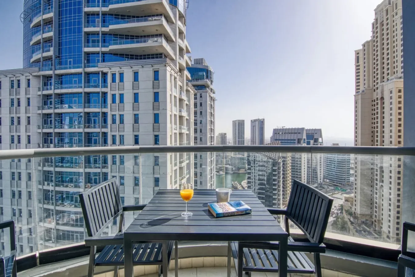 Una zona de estar en un balcón con vistas a edificios altos.
