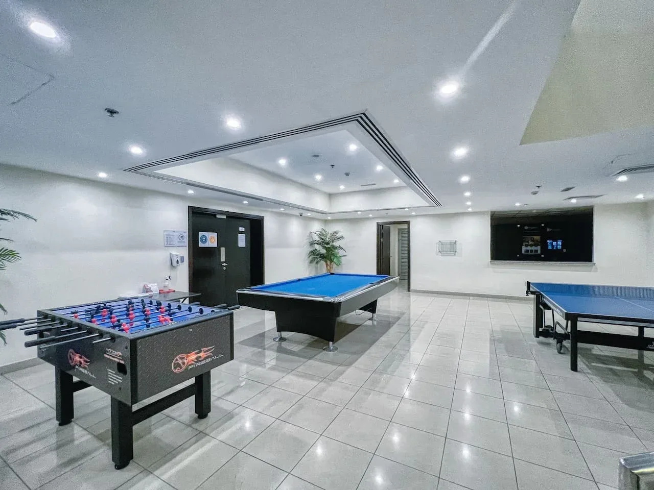 Una sala recreativa con mesas de futbolín, billar y ping-pong.