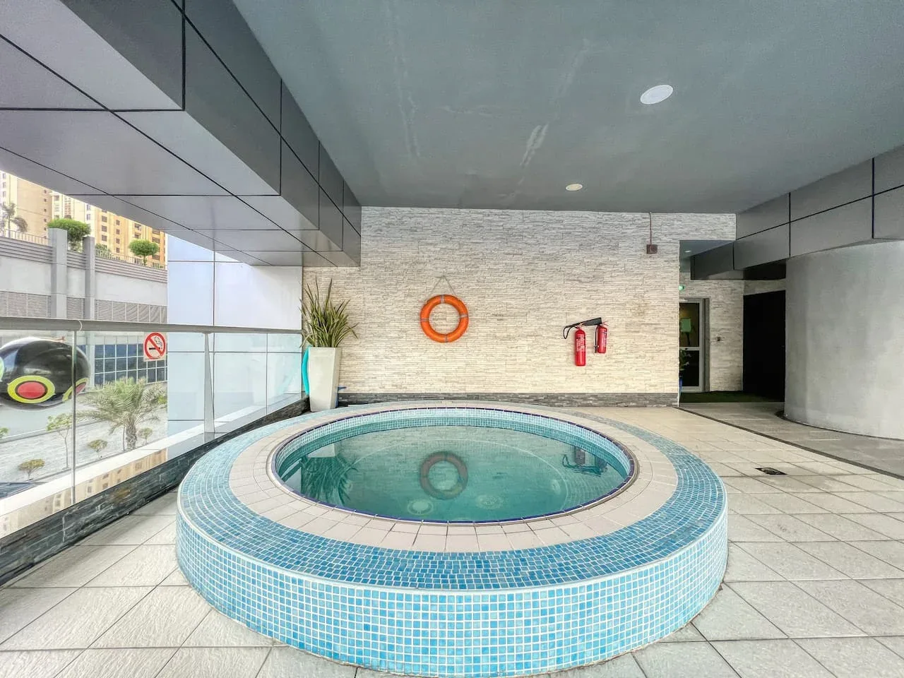 Una zona de piscina cubierta presenta una piscina redonda revestida de azulejos.