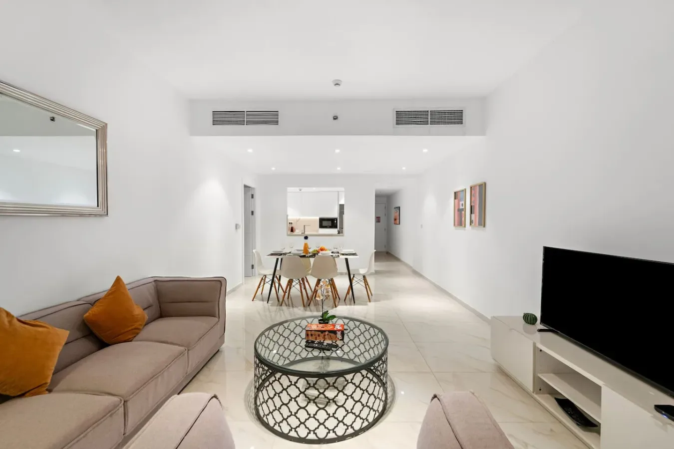 Una luminosa sala de estar y comedor con sofá, mesa de centro y mesa de comedor.