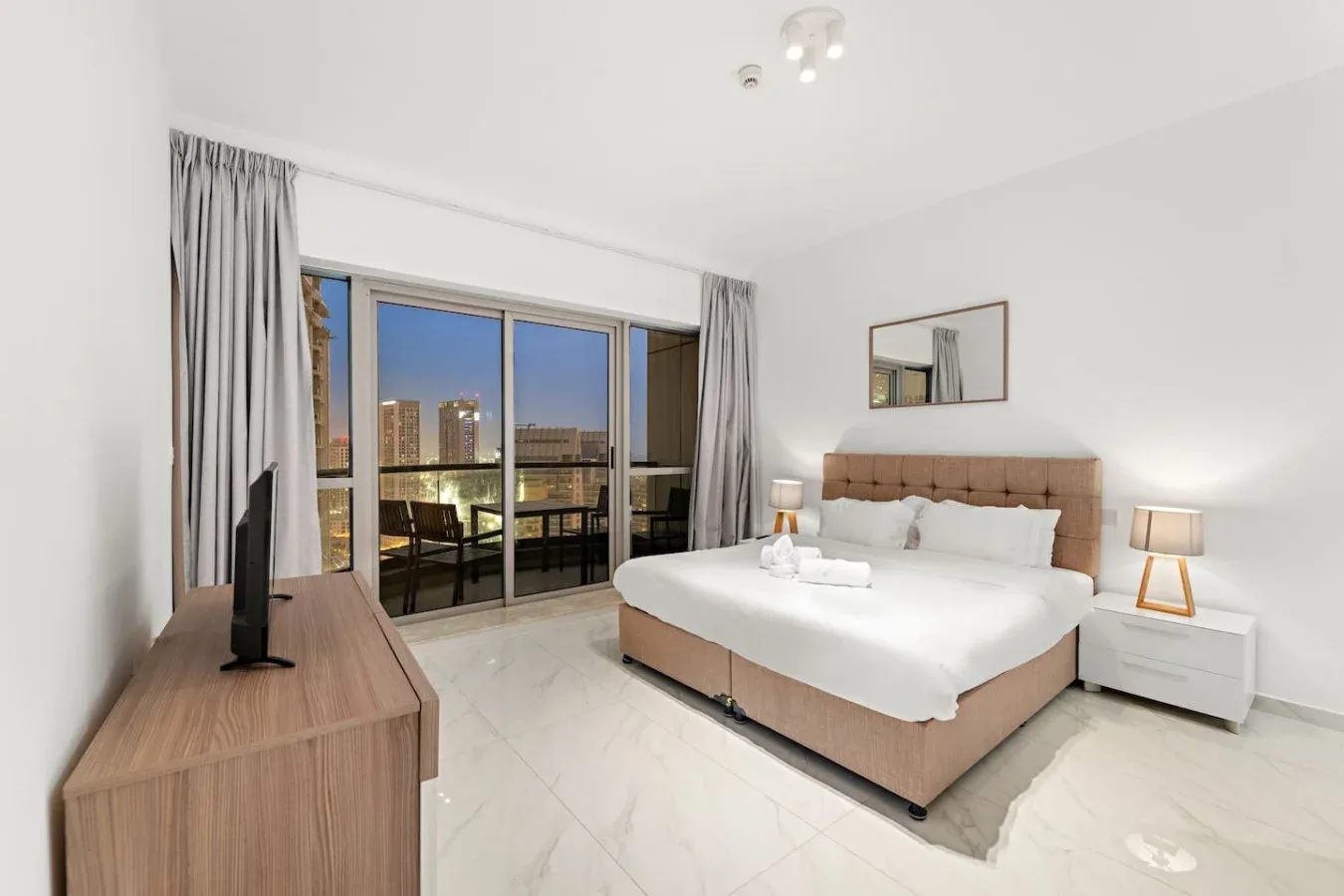 Un dormitorio con una cama junto a una puerta corrediza de vidrio que da a un balcón.