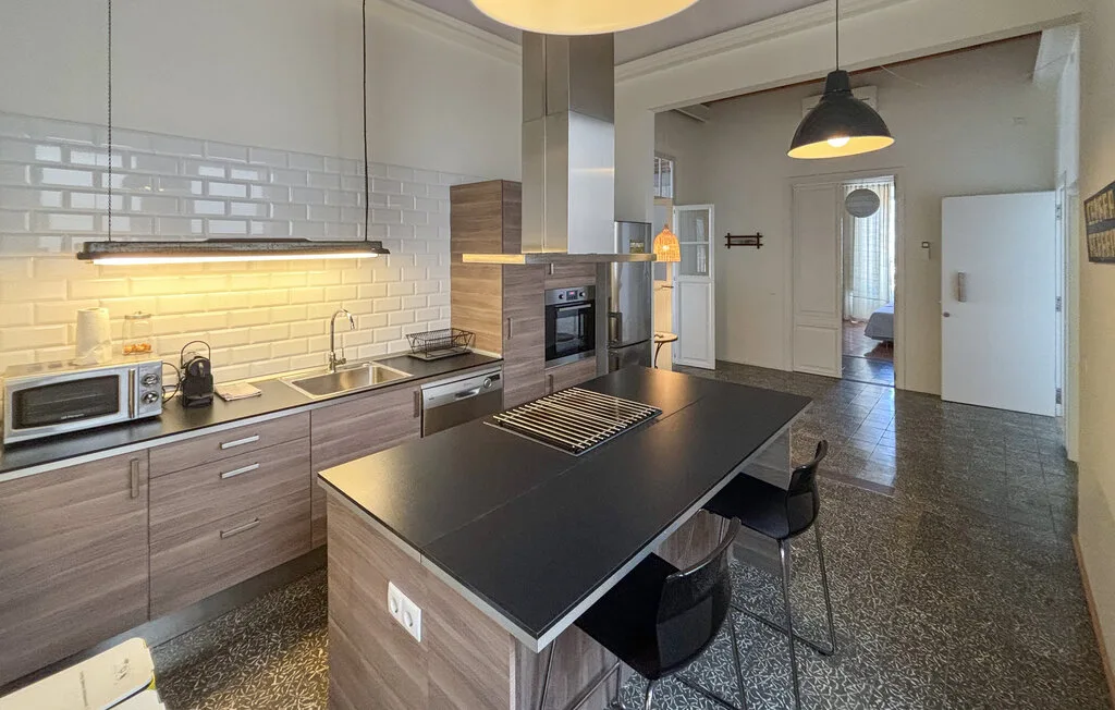 Una cocina moderna con una isla oscura y un horno empotrado.