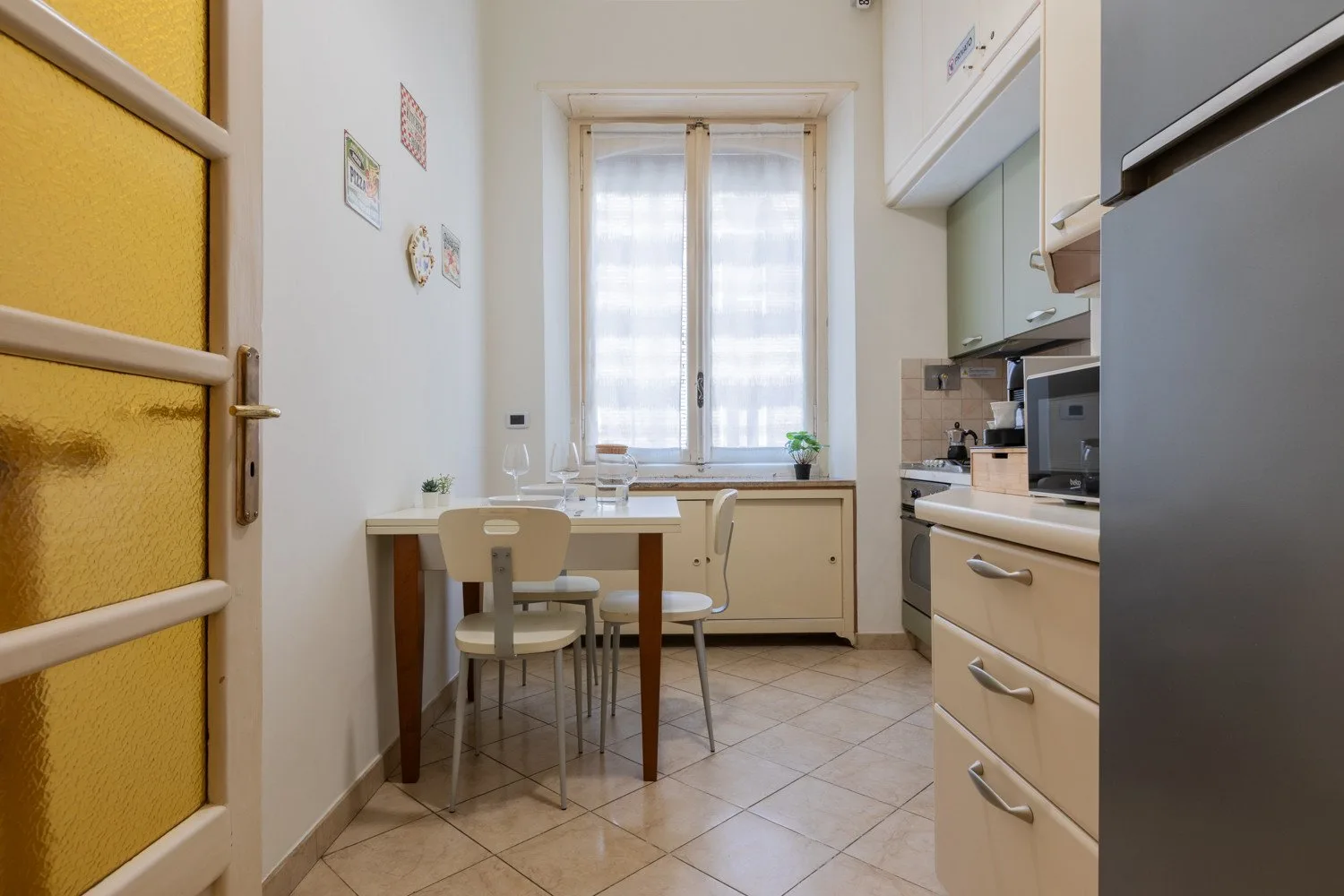 Una cocina compacta con una pequeña mesa de comedor junto a una ventana.