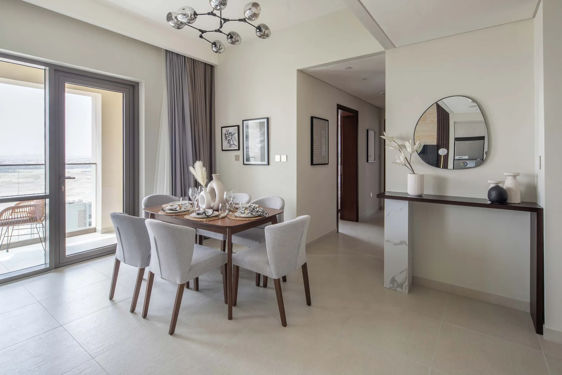 Comedor con una mesa y asientos junto a grandes puertas de vidrio.