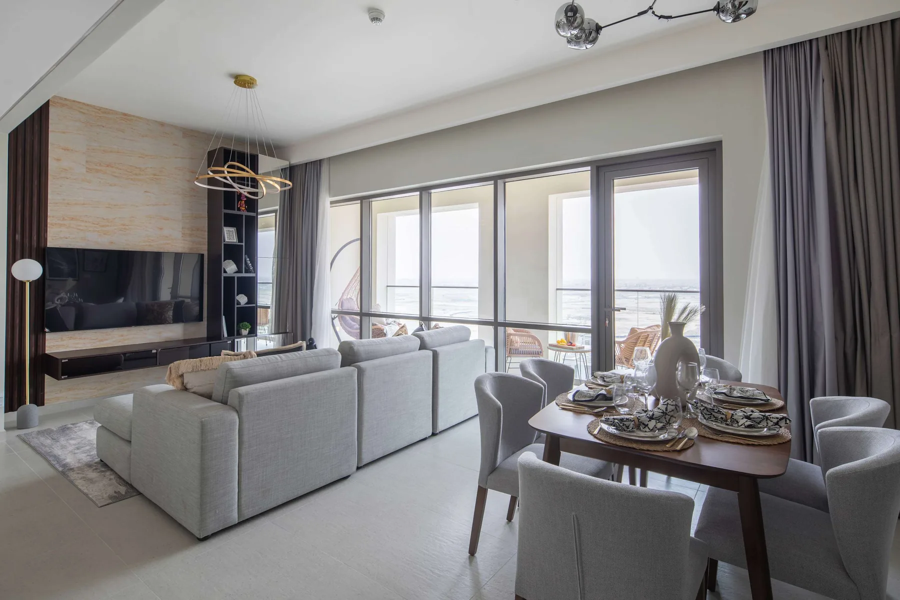 Una luminosa sala de estar y comedor con asientos junto a grandes ventanas.