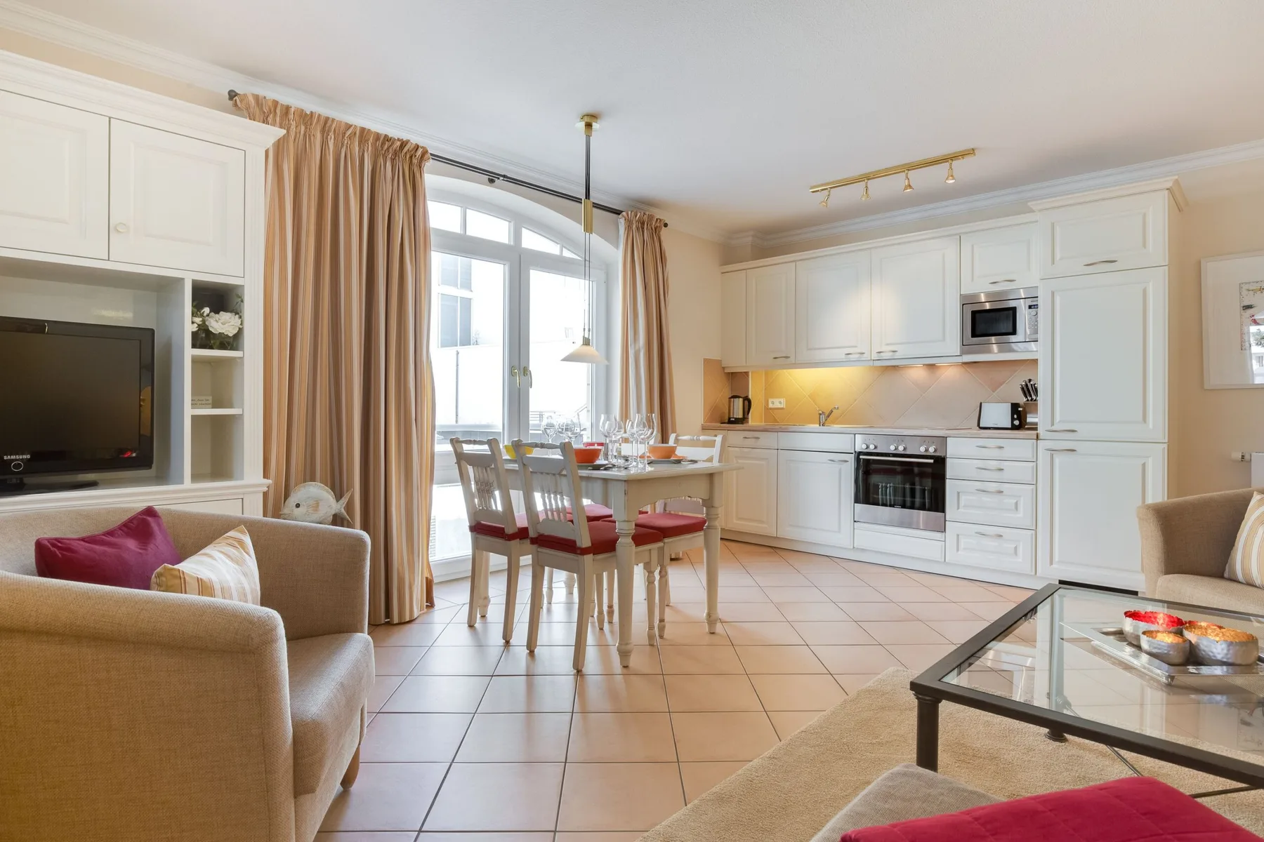 Una luminosa sala-comedor se abre a la cocina y cuenta con grandes ventanas.