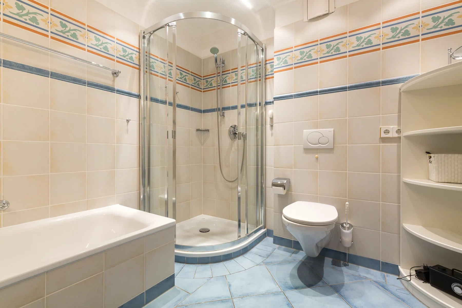 Un baño con azulejos, una ducha curva de vidrio y una bañera.