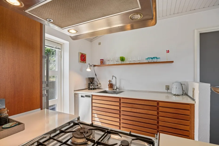 Una cocina compacta con gabinetes de madera, una encimera y una estufa de gas.