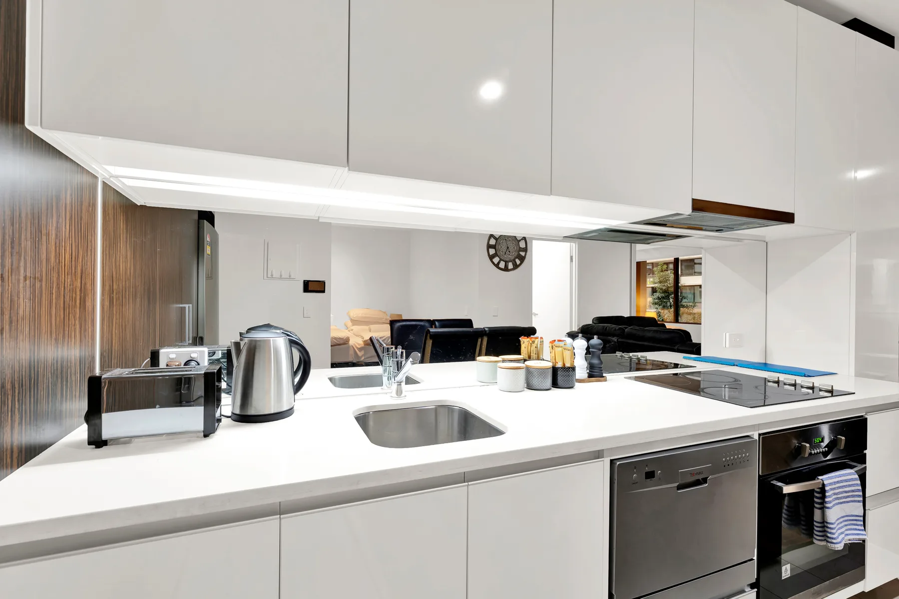 A bright kitchen with a white countertop, sink, and cooking appliances.