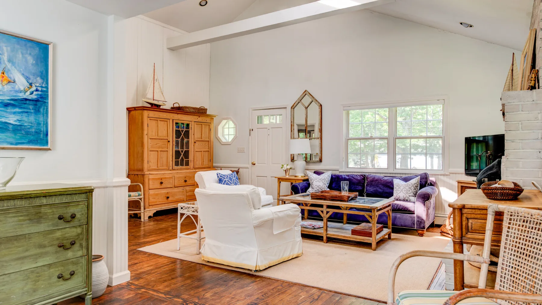 A bright living room with seating arranged around a low wooden coffee table.
