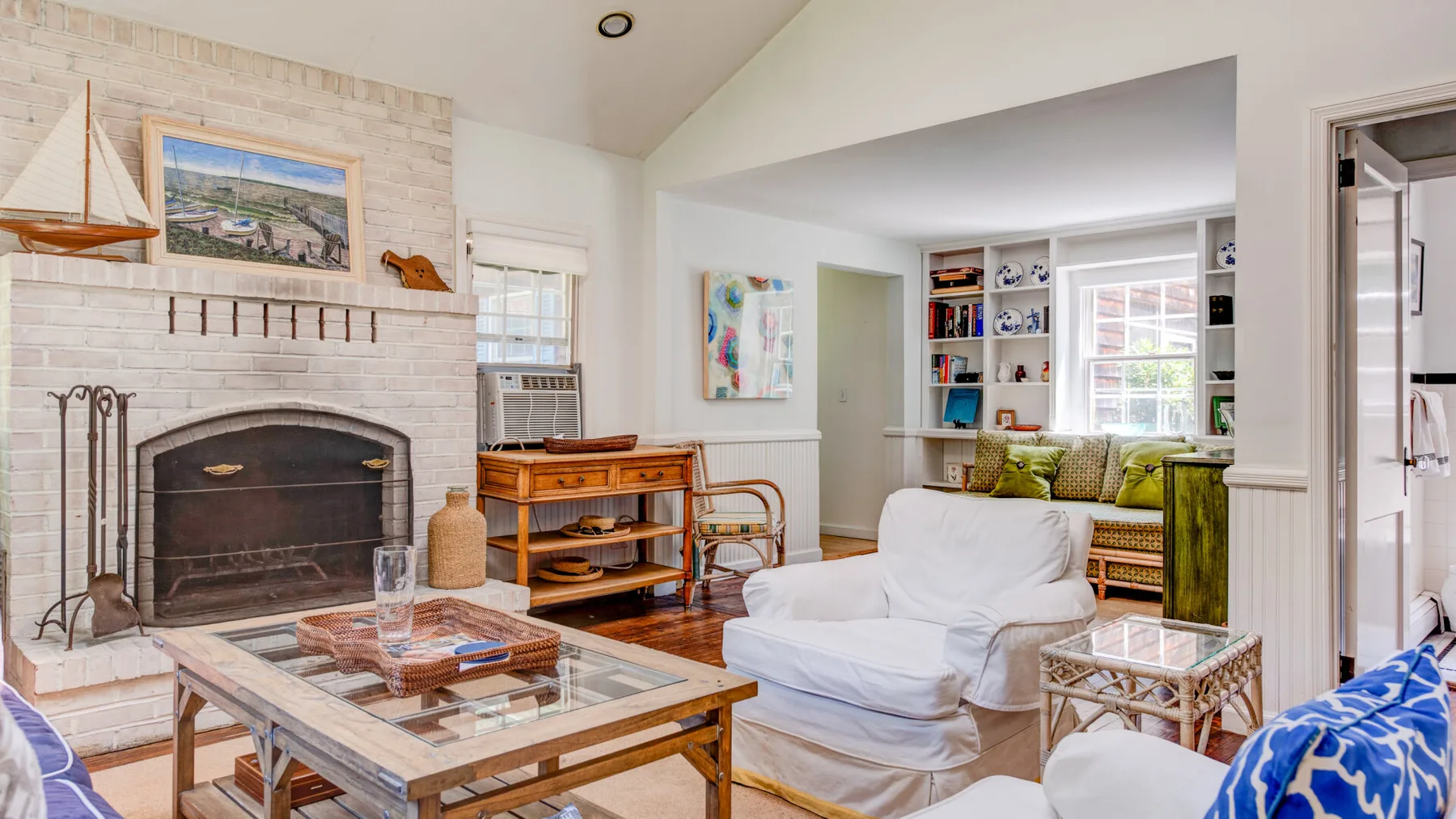 A bright living room with a fireplace, seating, and a coffee table.