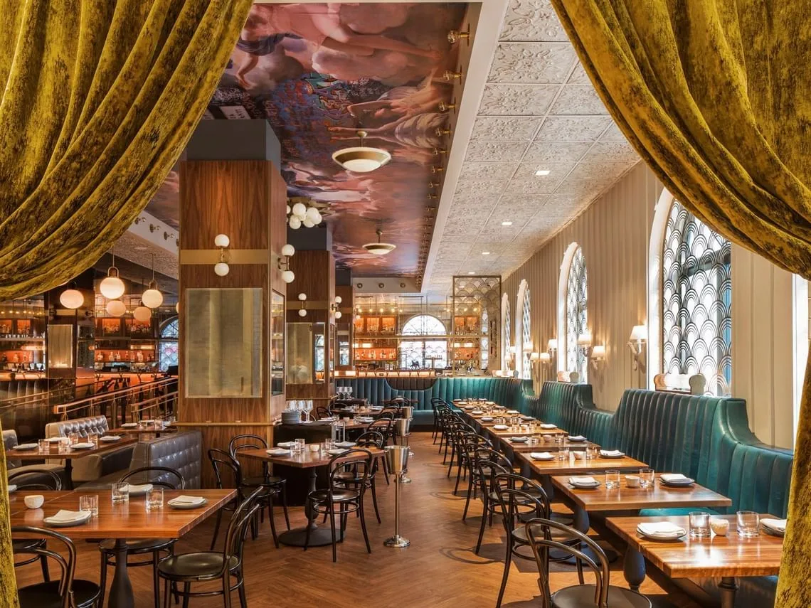 Ciaorigato Restaurant interior with teal banquettes, wooden tables, and a decorative ceiling mural