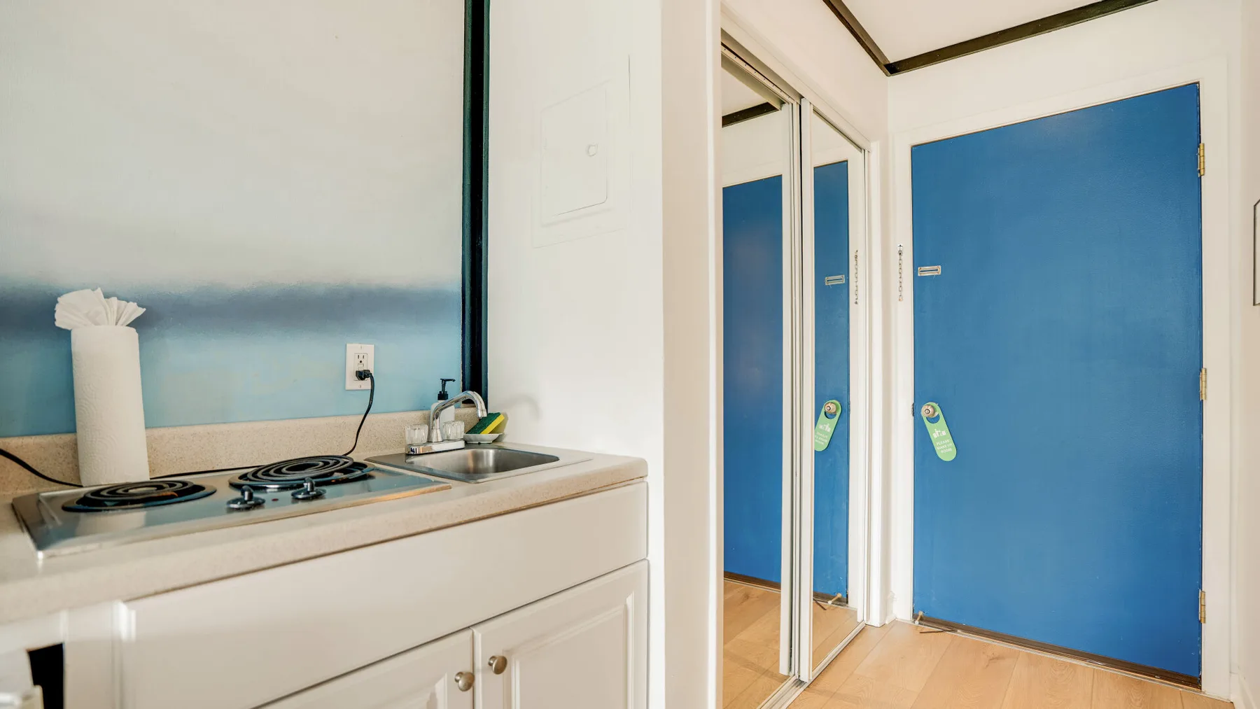 Una pequeña cocina con una placa de cocción y puertas azules.