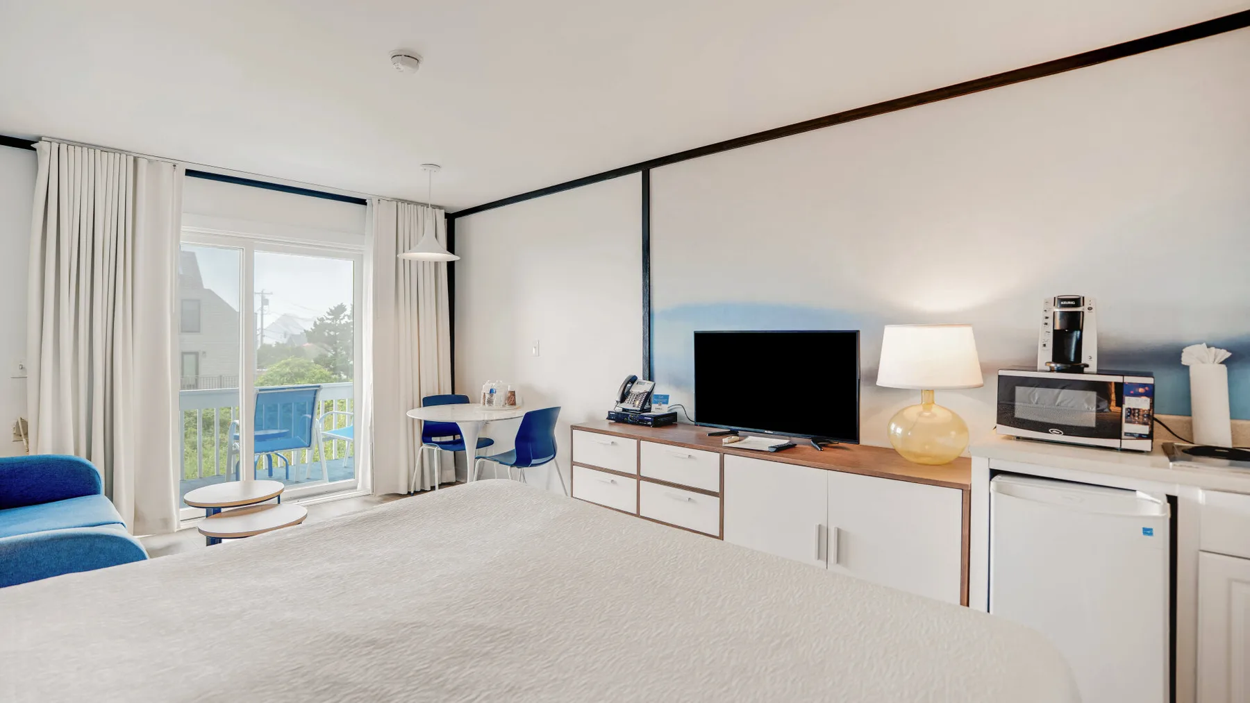 Un estudio luminoso con cama, mesa de comedor y zona de cocina.