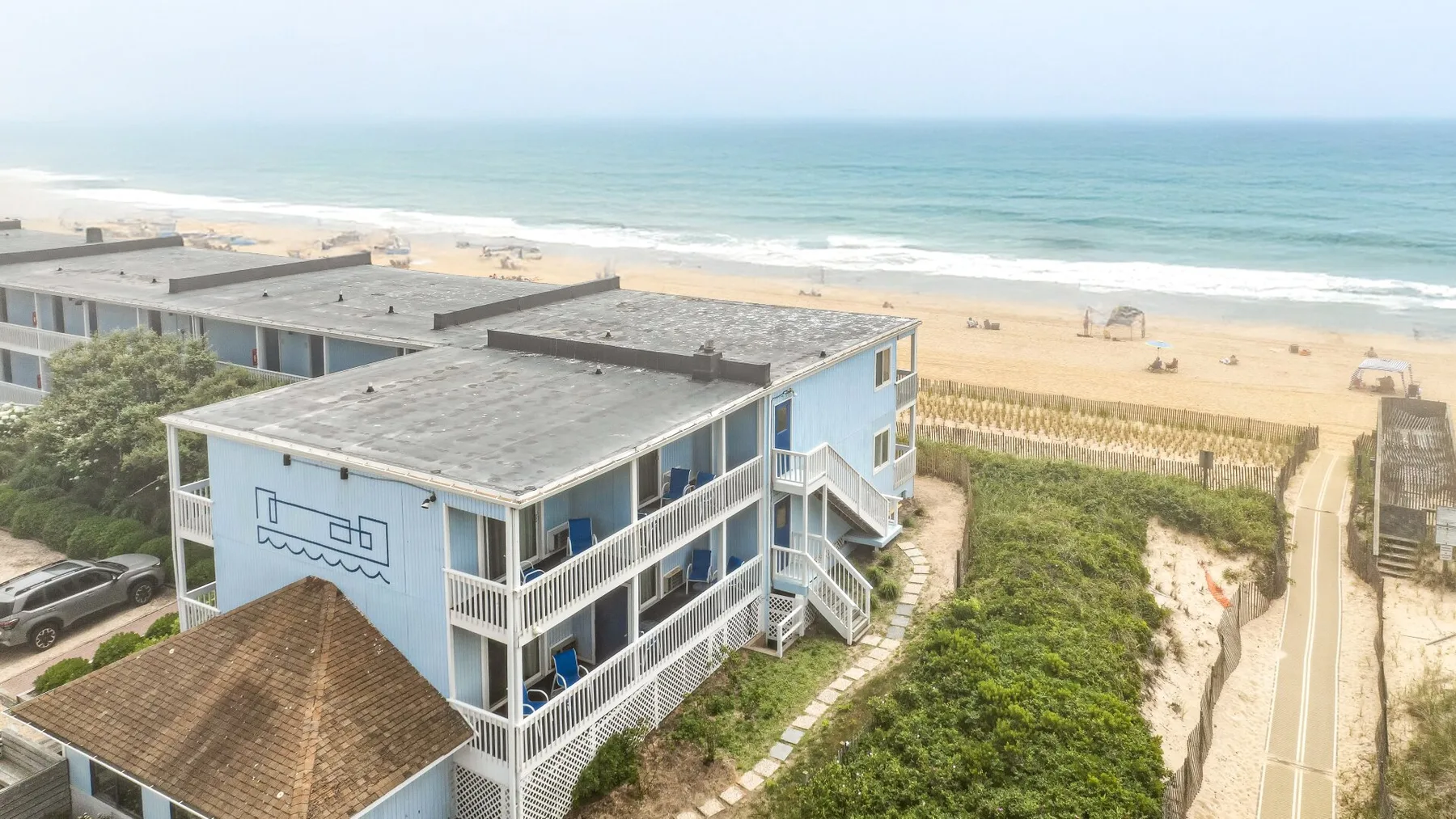 Un edificio frente a la playa da a la costa arenosa y al océano.