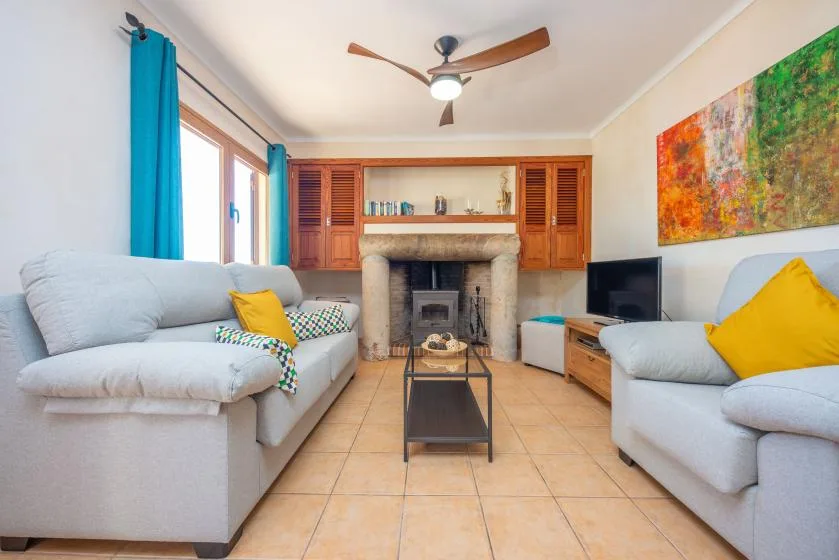 A living room with seating arranged around a fireplace and coffee table.