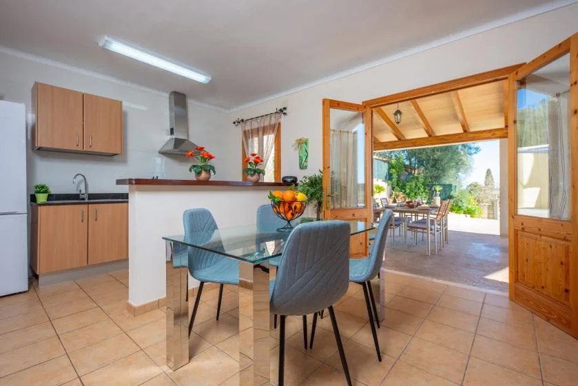 A dining area with a glass table and an open doorway to a patio.