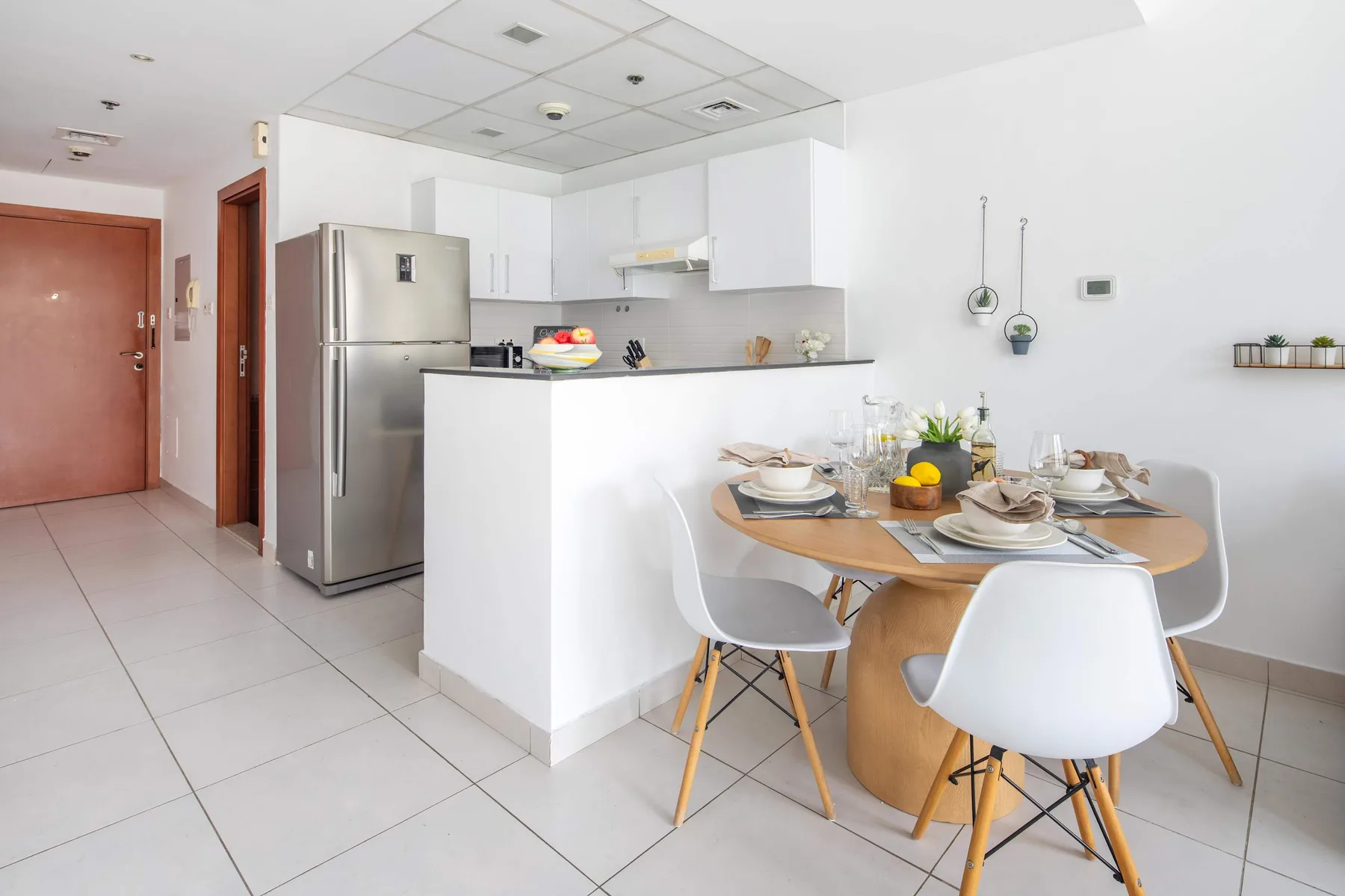 A bright kitchen and dining area with a table set for a meal.