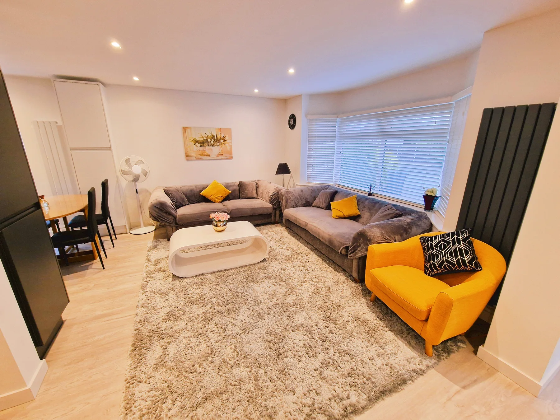 Living room with sectional seating, a rug, and a bright yellow armchair.