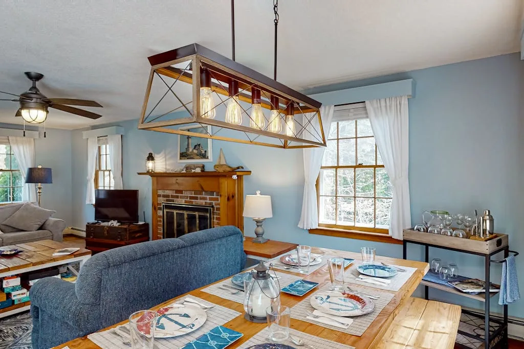 A dining area with a set table and a fireplace in the adjoining living space.