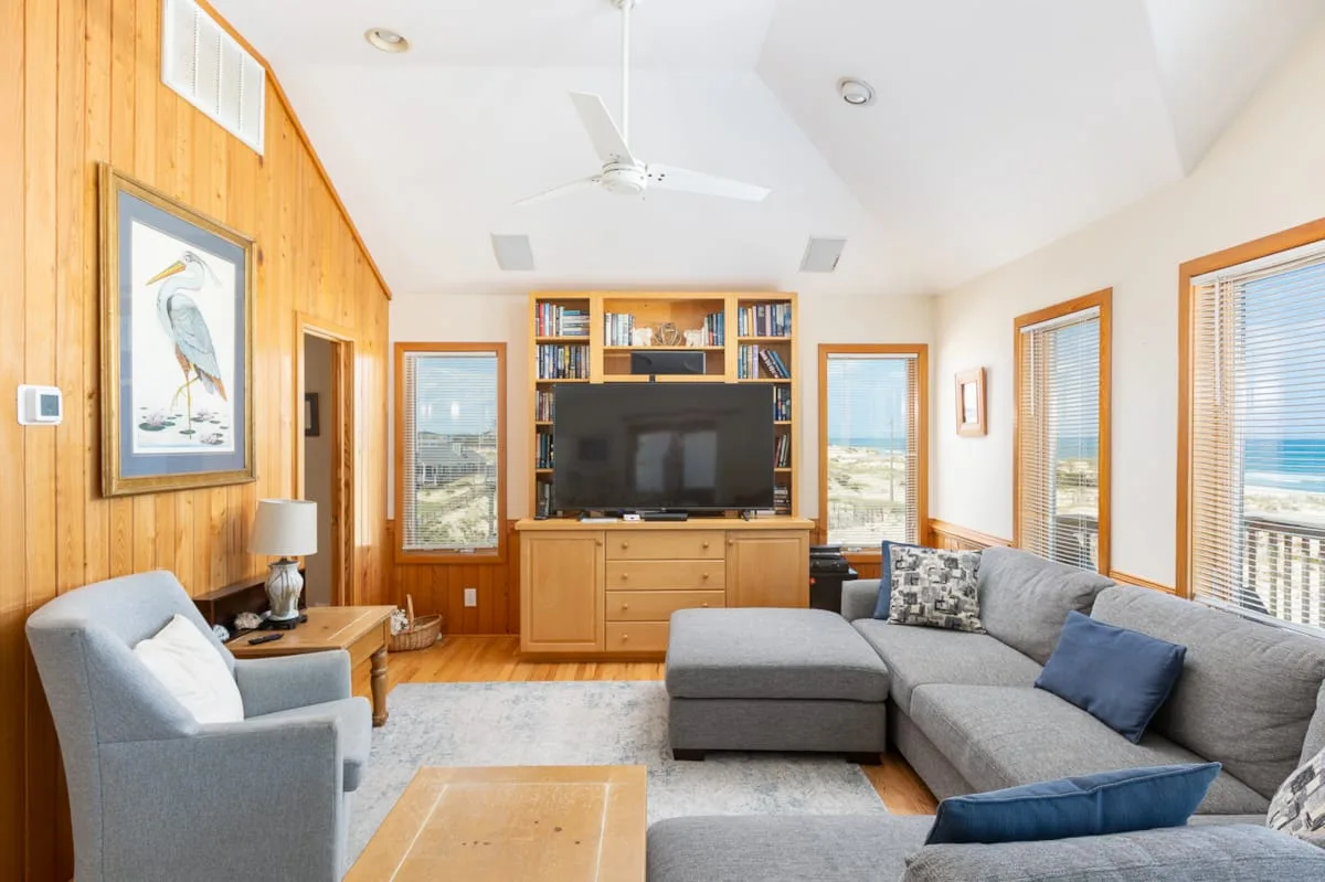 Una sala de estar con asientos alrededor de un televisor y muebles de madera.