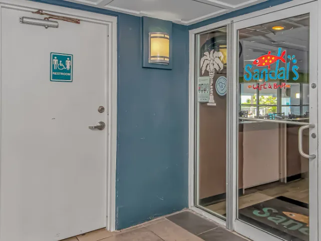 A restaurant entrance with glass doors and colorful signage.