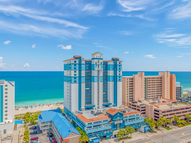 Aerial view of beachfront high-rise buildings beside the turquoise sea.