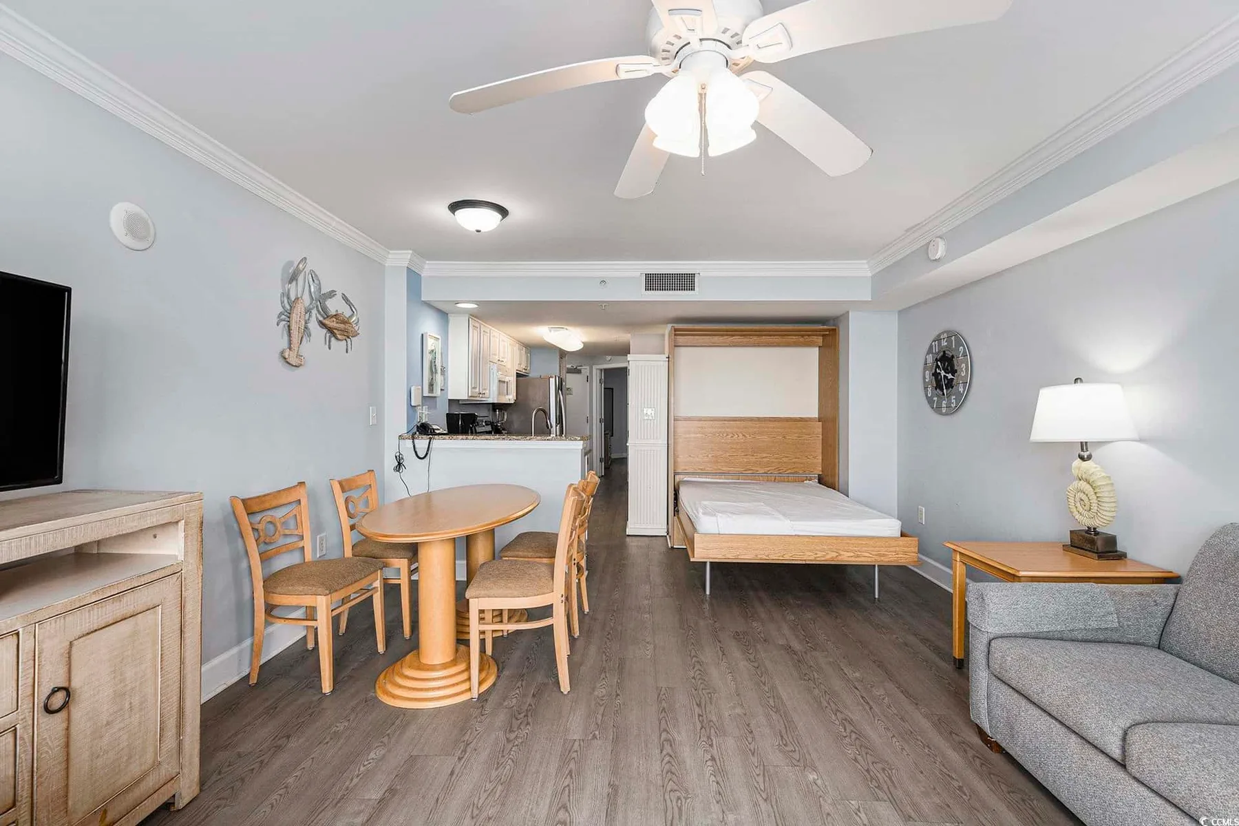 A studio room with a bed, dining table, and seating area.