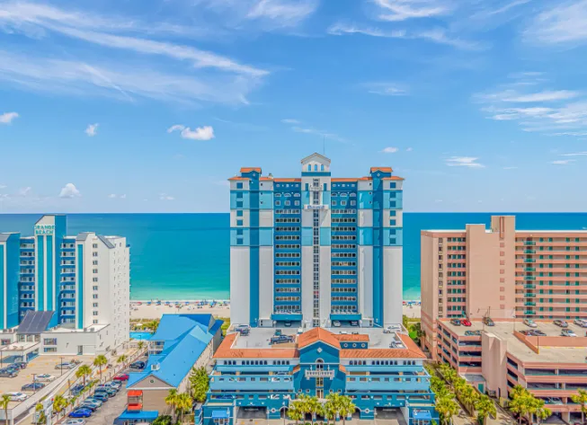 Coastal cityscape with high-rise buildings along a turquoise shoreline.