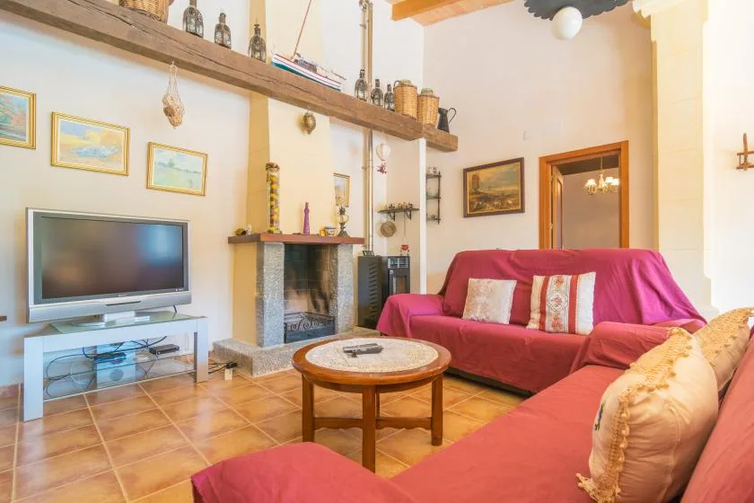 Una sala de estar con asientos, un televisor y una chimenea.
