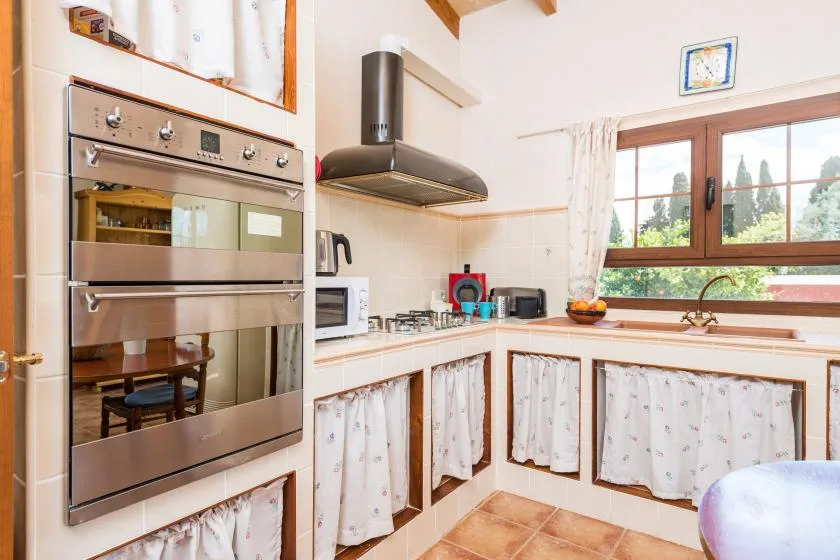 Una cocina luminosa con electrodomésticos empotrados y una ventana sobre el fregadero.