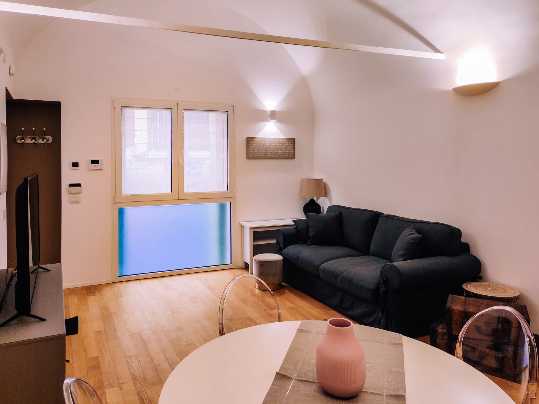 A living room with dark seating around a round table.