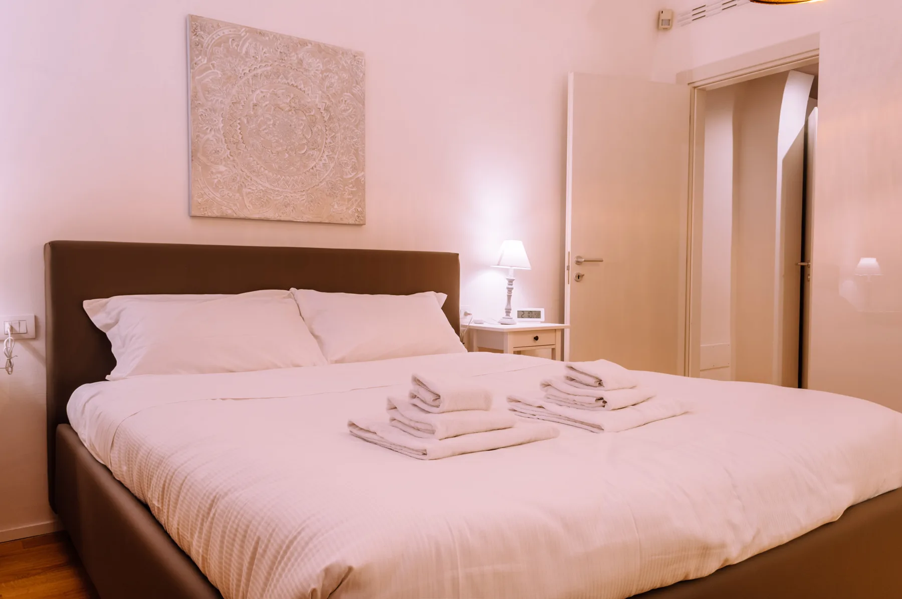 Un dormitorio con una cama bien tendida y toallas dobladas.