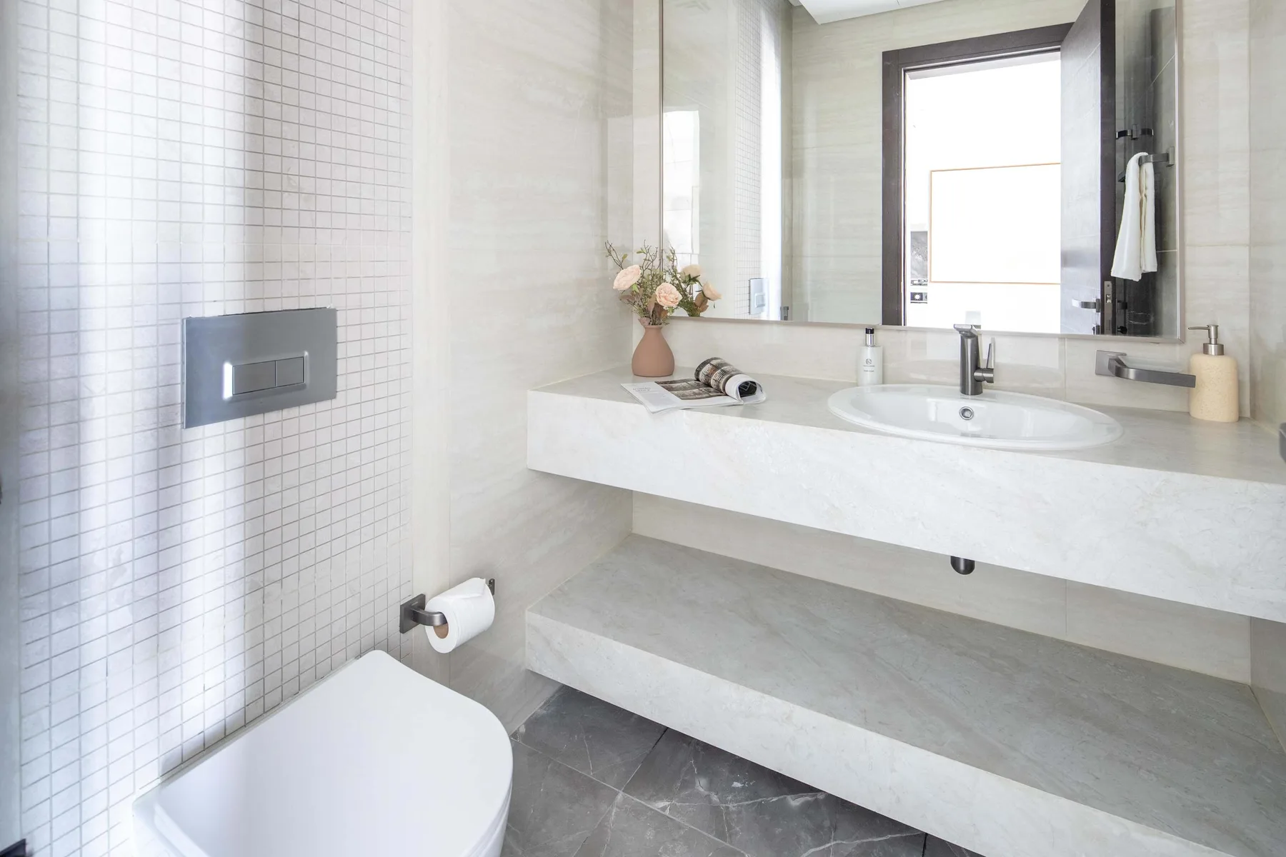 Un baño luminoso con un lavabo amplio y paredes revestidas de azulejos.