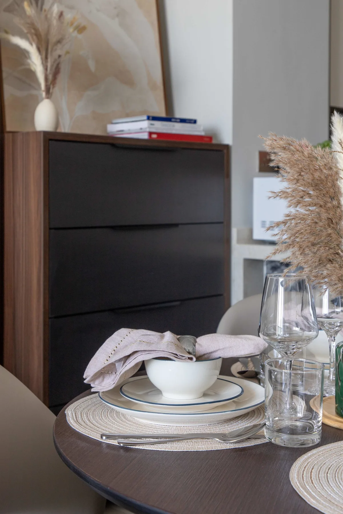 Una mesa de comedor está puesta con platos, un cuenco y vasos.