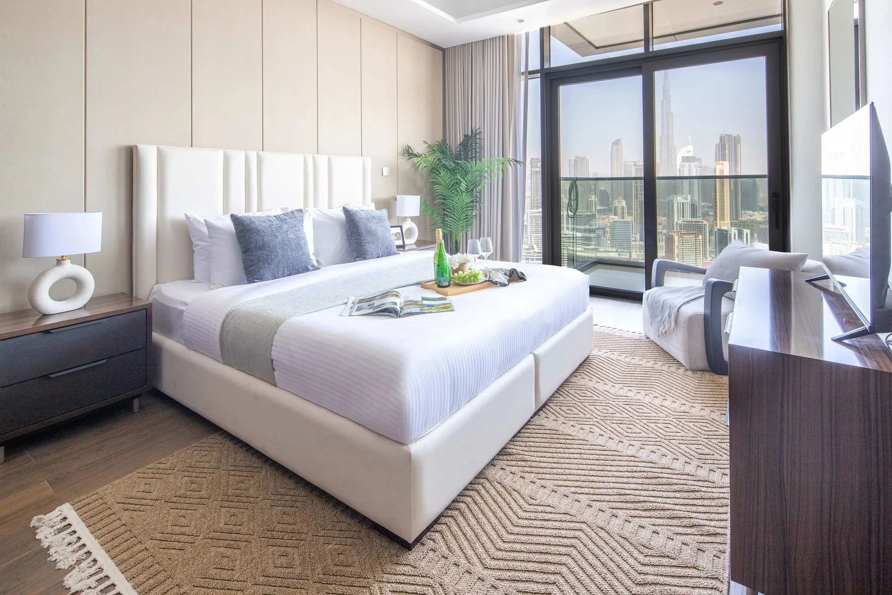 Un dormitorio luminoso con una cama grande junto a ventanales.