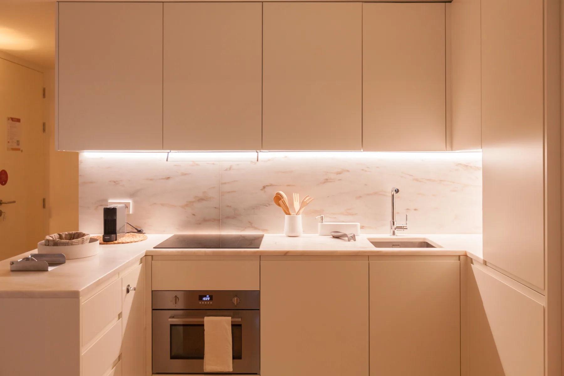 Una cocina moderna con gabinetes claros, una encimera y un horno.