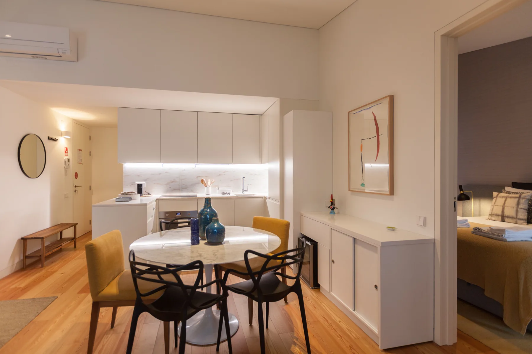 Comedor con mesa y asientos junto a una cocina abierta.