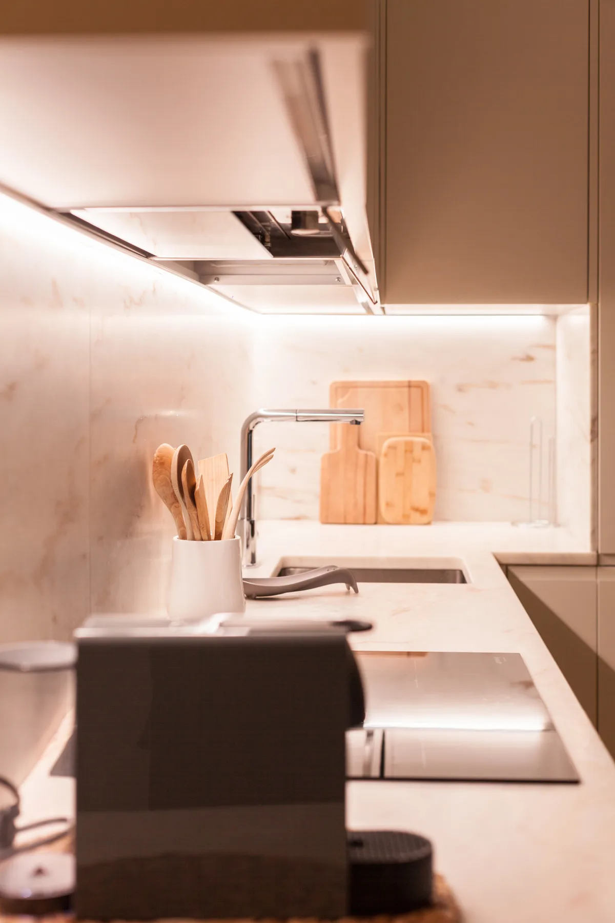 Una encimera de cocina moderna con fregadero, tablas de cortar y utensilios de cocina.