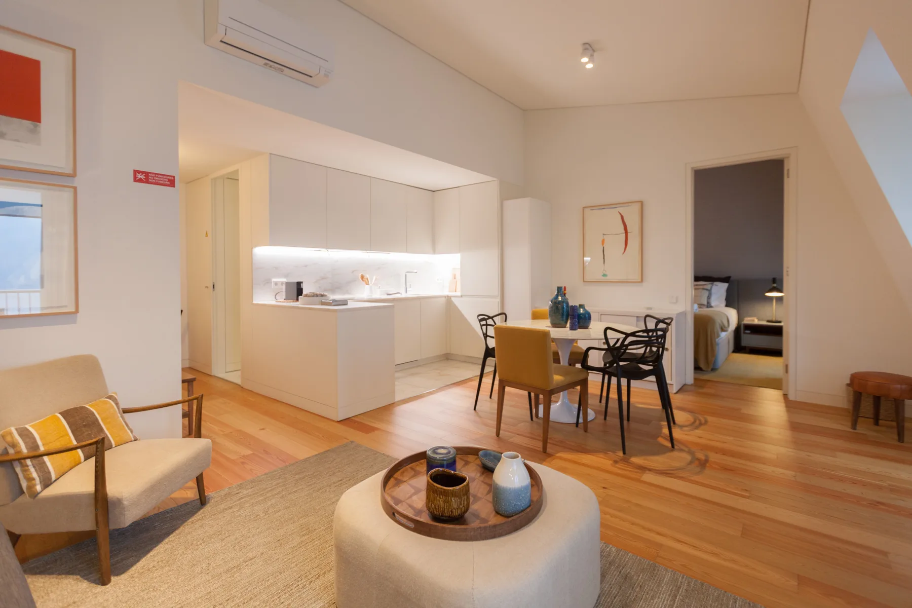 Una sala de estar diáfana con mesa de comedor y una cocina luminosa.
