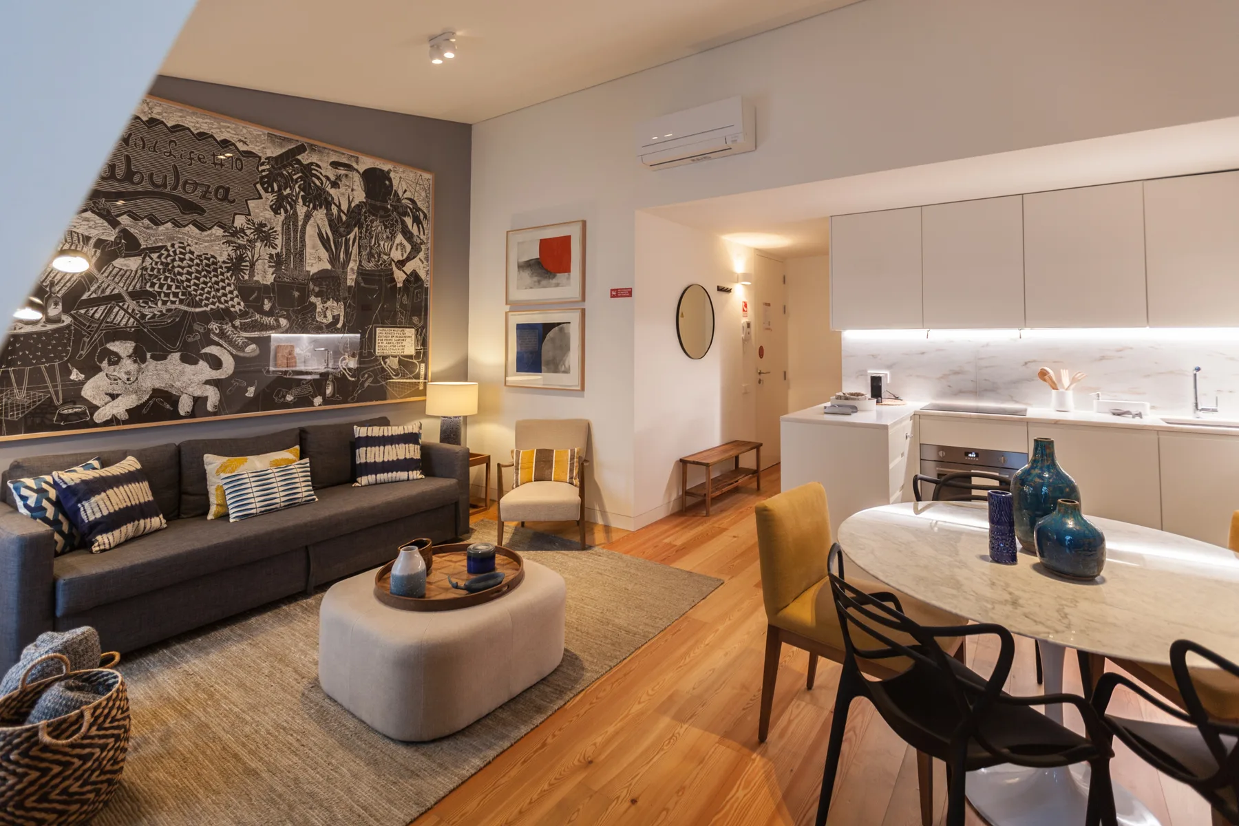 Una sala-comedor de planta abierta con un sofá oscuro y una cocina.