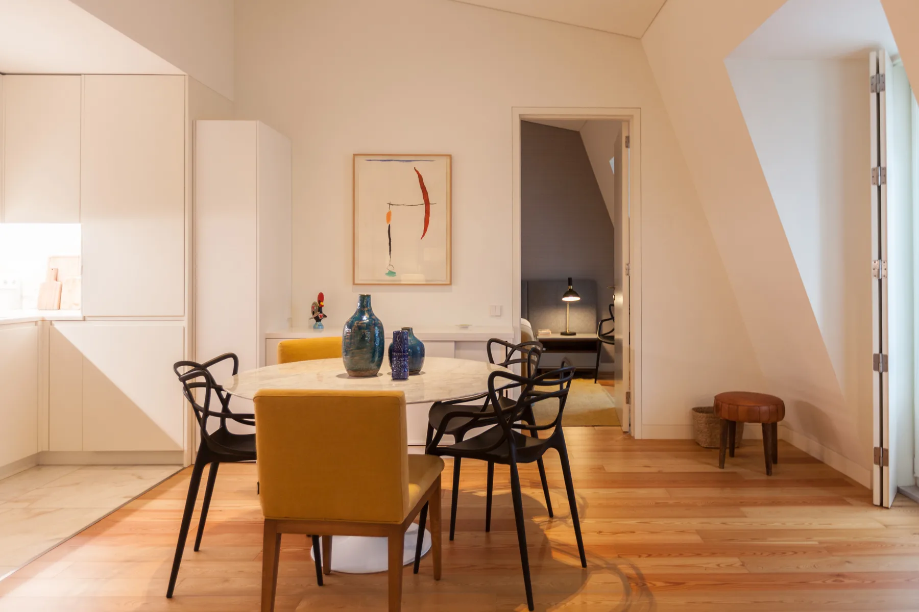 Comedor con una mesa y asientos, junto a una puerta abierta.