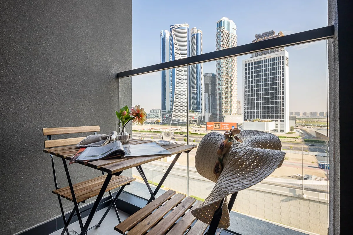 Una zona de asientos en un balcón ofrece vistas de varios edificios modernos.