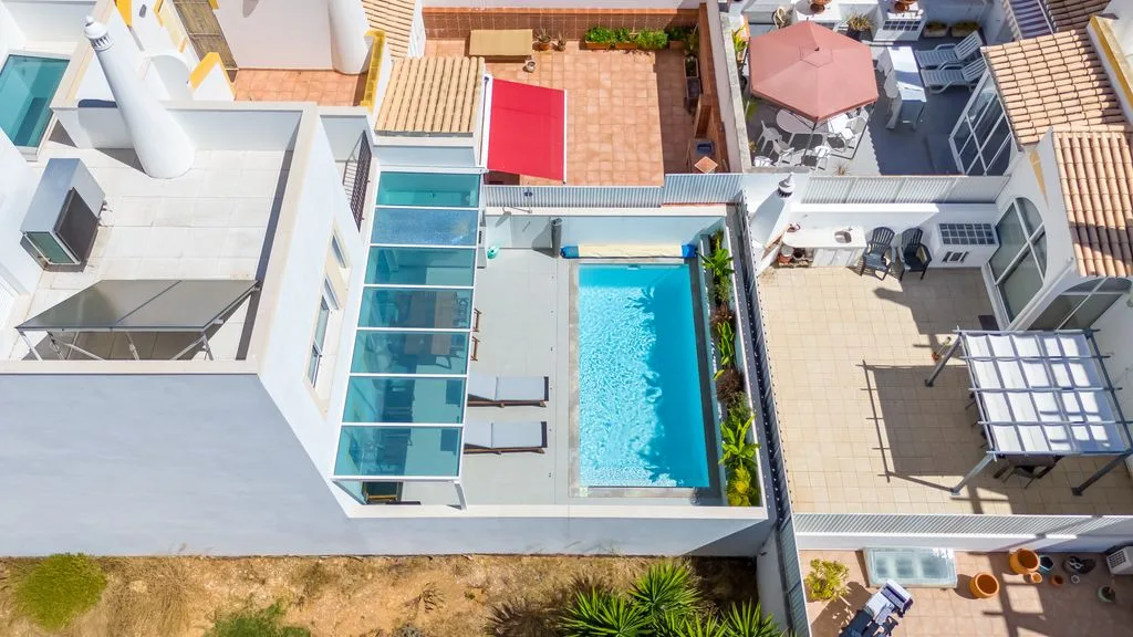 Aerial view of a courtyard pool surrounded by tiled patios and seating.