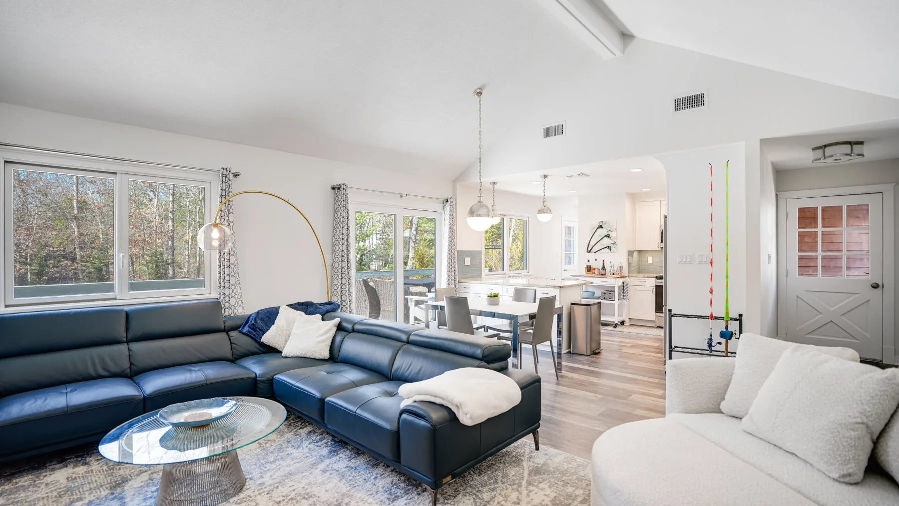 A bright open-plan living room with sectional seating and a dining area.