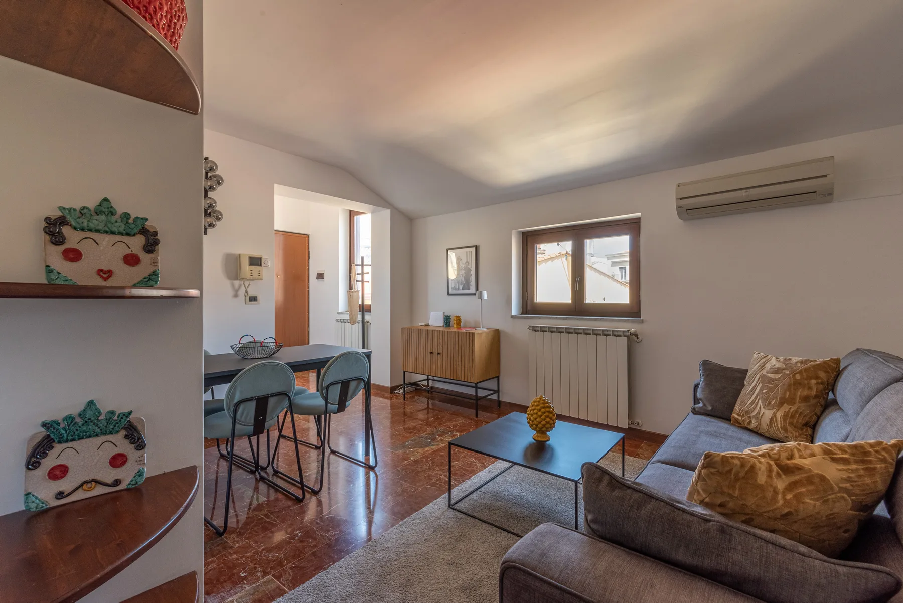 Sala de estar con asientos, una mesa de centro y un comedor contiguo.