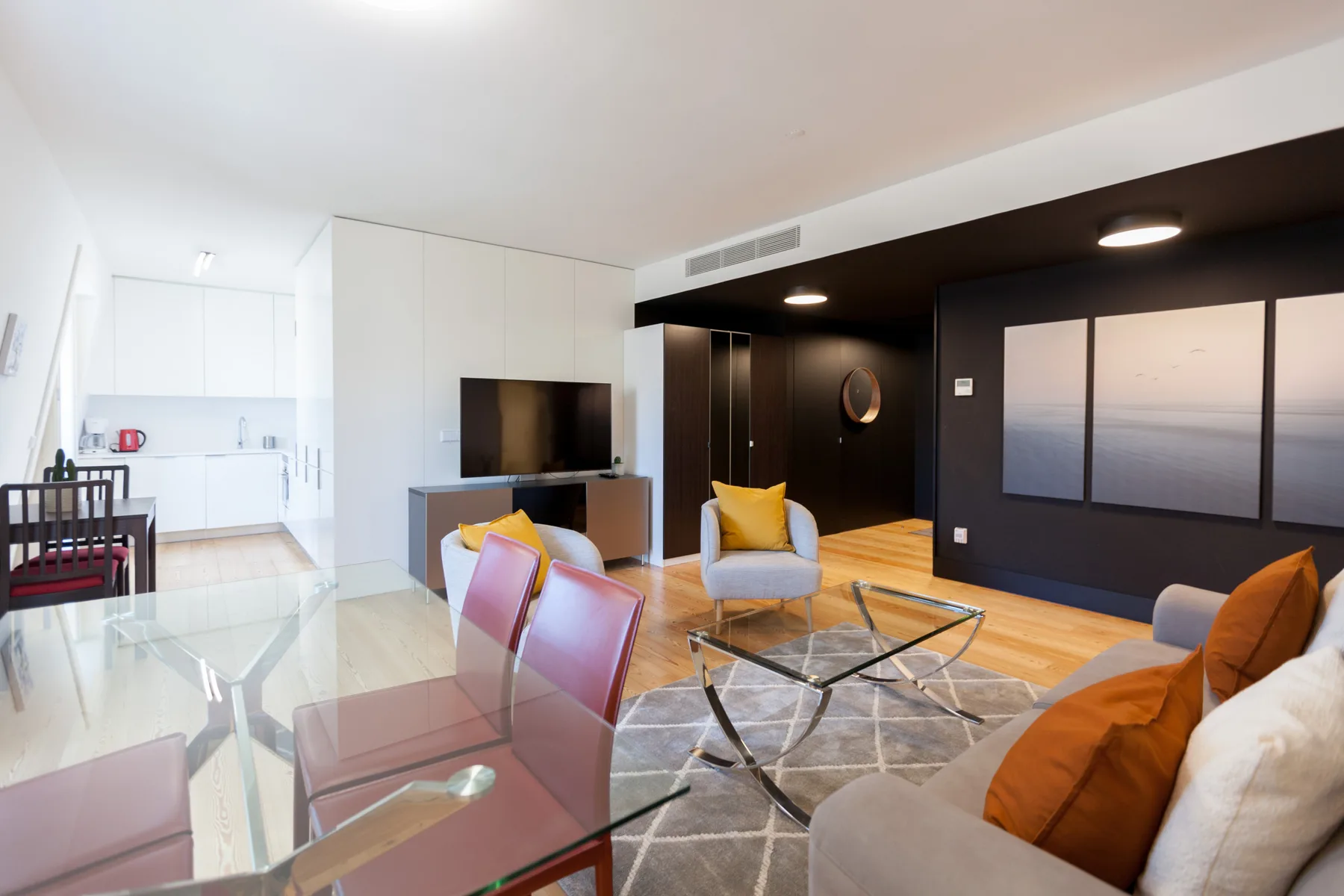 Una sala-comedor de planta abierta con una mesa de cristal y asientos.